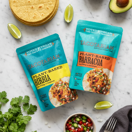 Two packages of Tacotarian plant-based meals on a marble surface with tortillas and lime wedges.